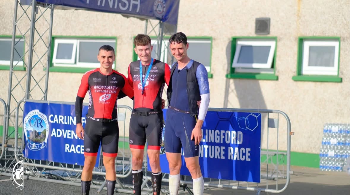 Three male finishers on the podium under the finish arch at the 2026 Carlingford Adventure Race