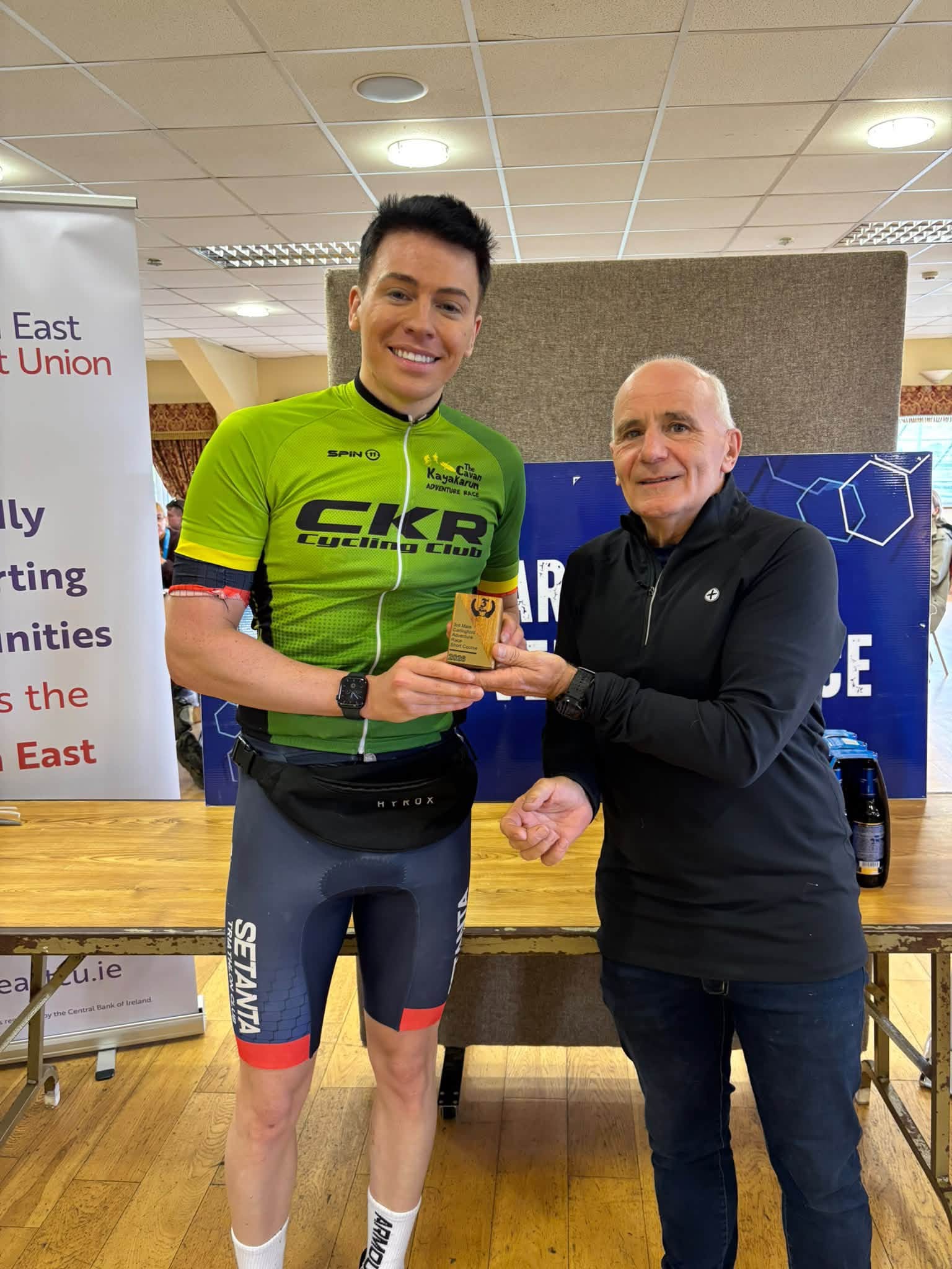 Prize giving: a winner in a green CKR Cycling Club jersey is presented with a trophy